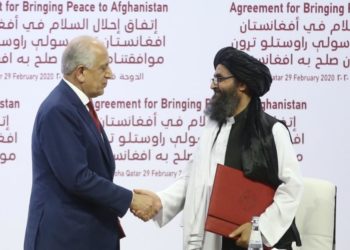 الملا عبد الغني برادر نائب الشؤون السياسية لحركة طالبان والمبعوث الأميركي زلماي خليل زاد وقعا الاتفاق (الأناضول)